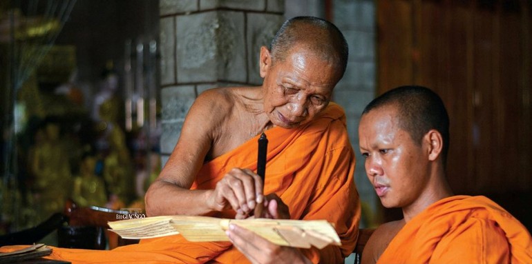Trưởng lão Hòa thượng Chau Ty, Phó Pháp chủ GHPGVN, đang ân cần hướng dẫn các sư viết kinh trên lá buông theo truyền thống Khmer - Ảnh: Quảng Đạo/BGN