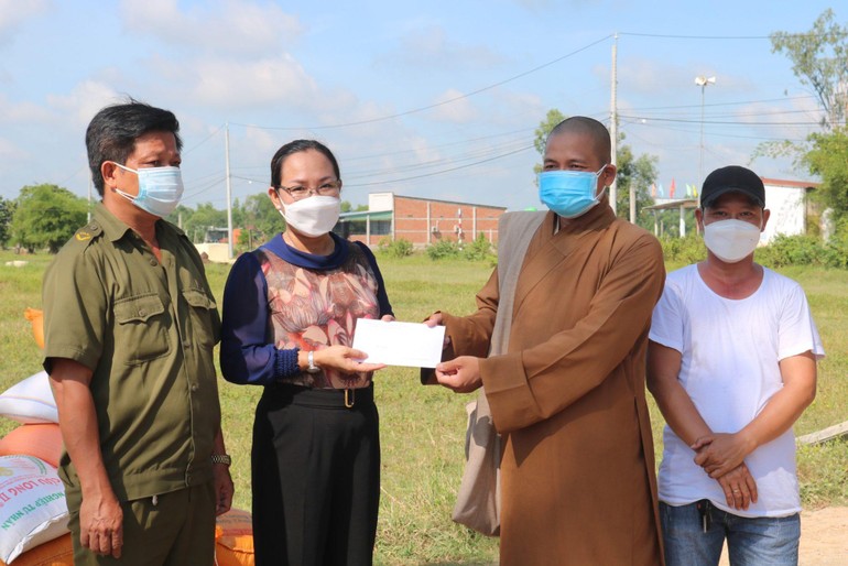 Đại đức Thích Lê Duyên trao quà đến bà Nguyễn Thị Thu Hà, Phó Chủ tịch UBND xã Hiệp Hòa để hỗ trợ người dân