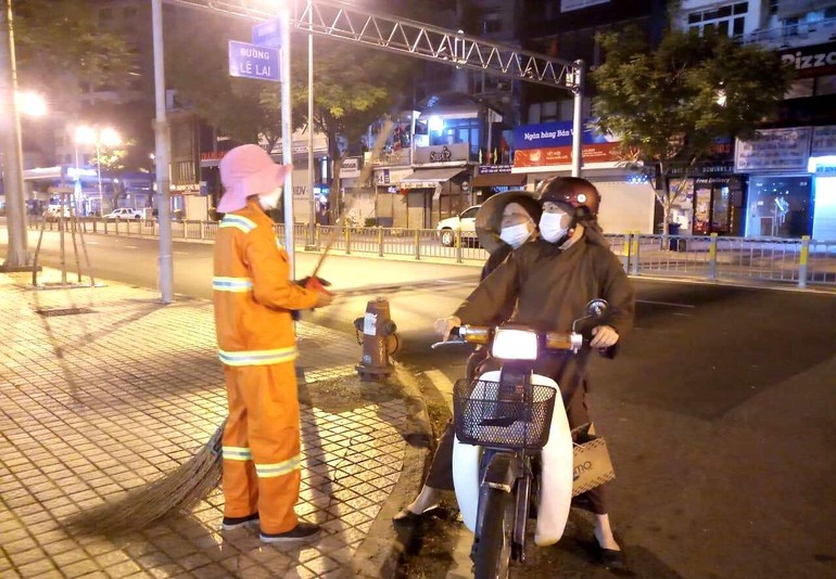 Ni trưởng Thích nữ Tịnh Nguyện đi xe máy thăm những công nhân làm vệ sinh ca đêm