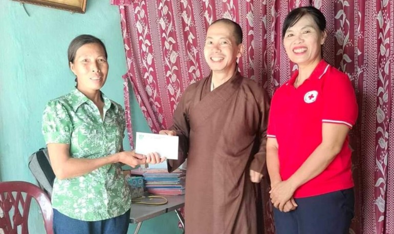 Đại diện Hội Chữ thập đỏ H.Quảng Ninh và chùa Kim Nại trao tiền đến gia đình học sinh khó khăn 