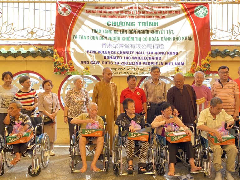 Đại diện các đơn vị tặng xe lăn đến người khuyết tật khó khăn, tại chùa Long Hoa - Ảnh: TQ