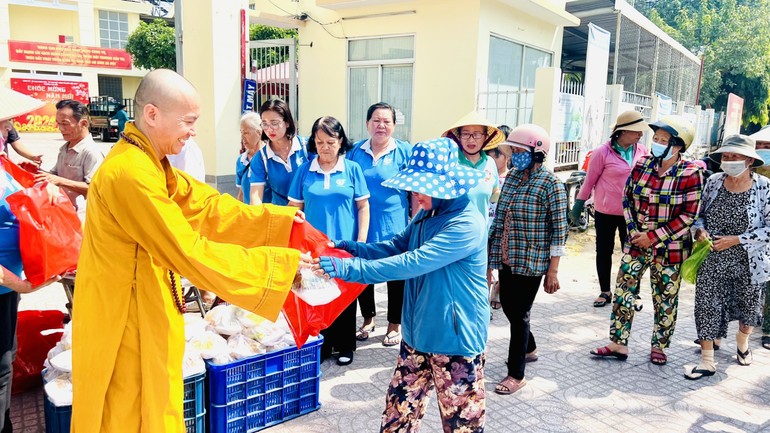 Thượng tọa Thích Đạo Phước trao các suất cơm chay đến người dân khó khăn tại P.Phú Hữu