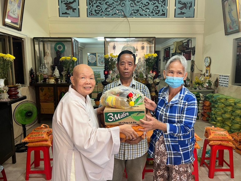 Ni sư Thích Nữ An Hương, nguyên Ủy viên Ban Trị sự GHPGVN quận 6, trụ trì chùa Pháp Thành trao quà đến người dân