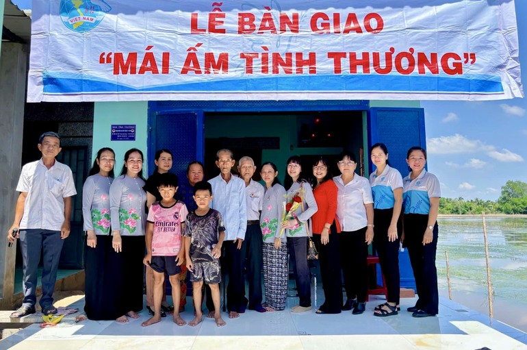 Đoàn dâng hoa Hữu Thiện bàn giao mái ấm tình thương đến gia đình bà Nguyễn Thị Thôi - Ảnh: D.H.H.T