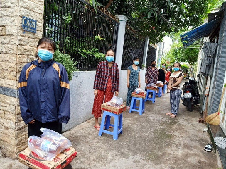 Người dân ở khu vực phong tỏa hẻm C8, đường Phạm Hùng, huyện Bình Chánh nhận quà hỗ trợ