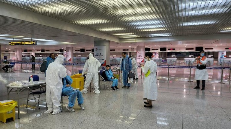 Lấy mẫu xét nghiệm nhanh kháng nguyên SARS-CoV-2 cho người nhập cảnh tại sân bay Tân Sơn Nhất - Ảnh: HCDC