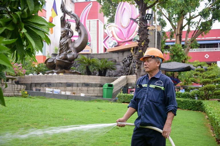 Anh Nguyễn Minh Hùng đang tưới cây trong Công viên Tượng đài Bồ-tát Thích Quảng Đức 