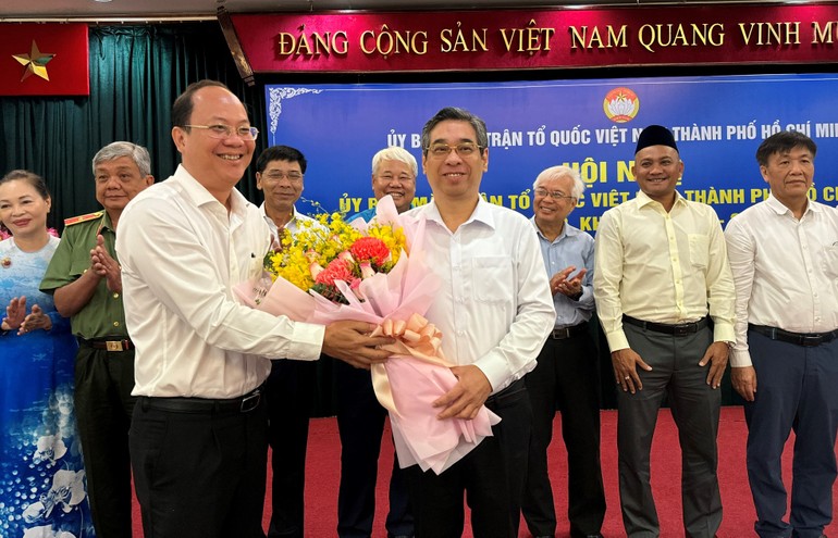 Phó Bí thư Thường trực Thành ủy Nguyễn Hồ Hải tặng hoa chúc mừng ông Nguyễn Phước Lộc nhận thêm nhiệm vụ - Ảnh: VGP/Vũ Phong