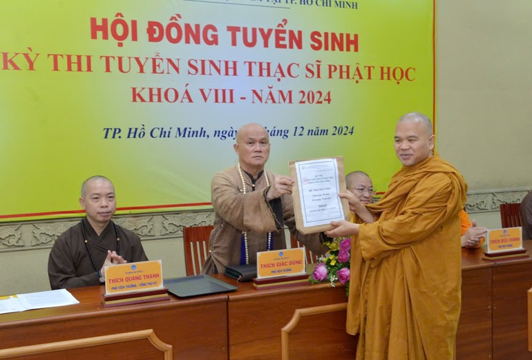 Thượng tọa Thích Giác Dũng trao bộ đề thi đến Thượng tọa Thích Giác Hoàng - đại diện Hội đồng coi thi