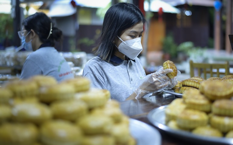 Một bạn trẻ đang kiểm tra bánh trung thu trước khi cho vào túi ni-lon bảo quản