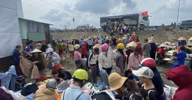 Người dân Tuy An Đông ra điểm tập kết hàng cứu trợ ở cầu Lò Gốm để nhận quần áo, nhu yếu phẩm chiều 25-11 - Ảnh: B.D