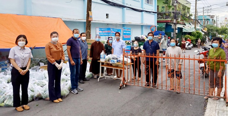 Đại diện chùa Pháp Vân, nhóm sinh viên Pháp Vân, UBMTTQVN quận Bình Thạnh trao quà đến người dân - Ảnh: SVTN Pháp Vân