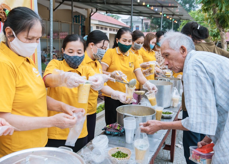 Các tình nguyện viên trao suất cháo đến bệnh nhân nghèo