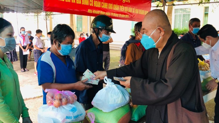 Hòa thượng Thích Chơn Tịnh, đại diện Ban Từ thiện - Xã hội báo Giác Ngộ trao quà đến những gia đình khó khăn - Ảnh: TQ