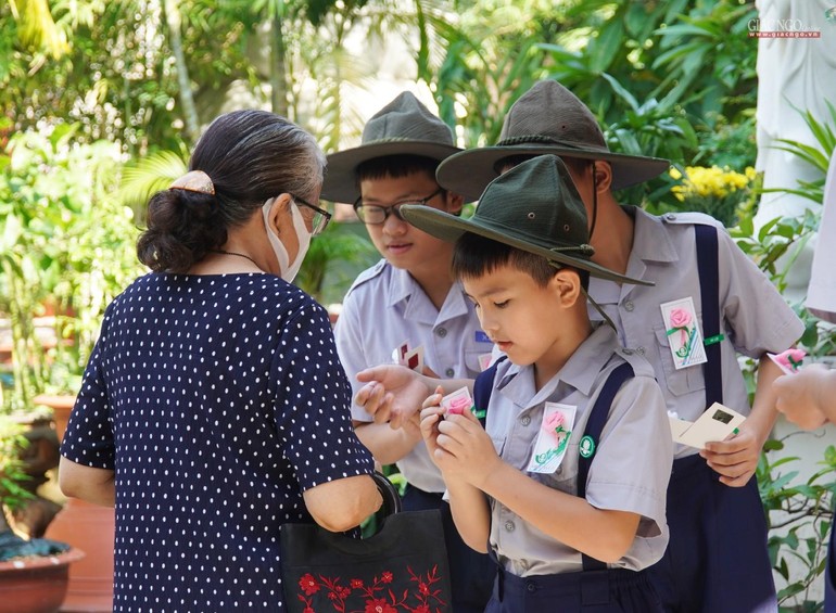 Các em Oanh vũ Gia đình Phật tử Xá Lợi cài hoa hồng Vu lan đến Phật tử sáng Rằm tháng Bảy