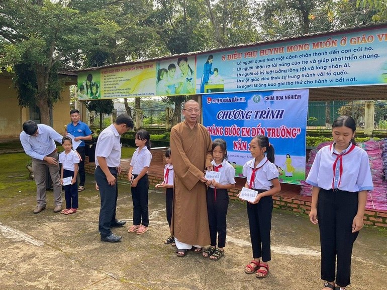 Thượng toạ Thích Quảng Tuấn, trụ trì chùa Hoa Nghiêm, cùng đoàn trao các suất học bổng đến các em học sinh