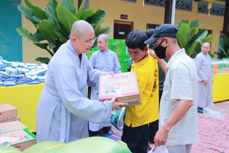 Ni sư Thích Chúc Tường, Phó Trưởng ban Thường trực Phân ban Ni giới TP.Thủ Đức, trụ trì chùa Kiều Đàm trao quà đến người dân - Ảnh: Trung Thắng