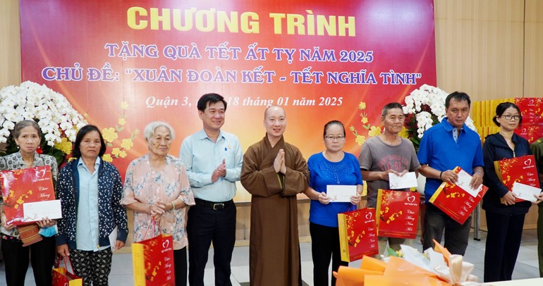 Thượng tọa Thích Nguyên Các, Phó trụ trì chùa Vĩnh Nghiêm, cùng ông Huỳnh Gia Giang, Chủ tịch UBMTTQVN Q.3 trao tặng quà Tết đến bà con trên địa bàn quận