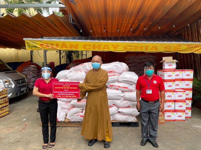 Thượng tọa Thích Huệ Công trao bảng hỗ trợ đến bà Phạm Thị Minh Nguyệt, Phó chủ tịch UBMTTQVN quận 8