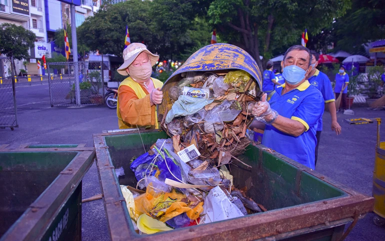 Hòa thượng Thích Duy Trấn cùng thành viên Câu lạc bộ Hành Trình Xanh - chùa Liên Hoa (Q.11) gom rác sau khi dọn dẹp trong khuôn viên Việt Nam Quốc Tự - Ảnh: Quảng Đạo/BGN