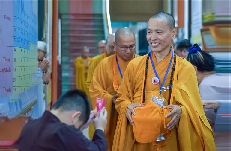 Một em bé dâng cúng thực phẩm đến chư Tăng - Ảnh: Quảng Đạo/BGN