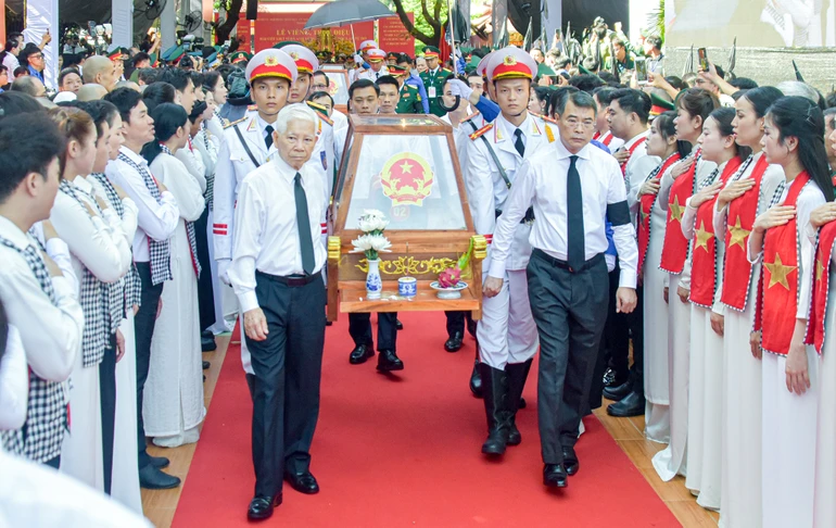 Thủ tướng Chính phủ Lê Minh Hưng cùng nguyên Chủ tịch nước Nguyễn Minh Triết di quan hài cốt liệt sĩ từ Công viên Lê Thị Riêng ra xe đưa về Nghĩa trang Liệt sĩ TP.HCM để an táng - Ảnh: Quảng Đạo/BGN