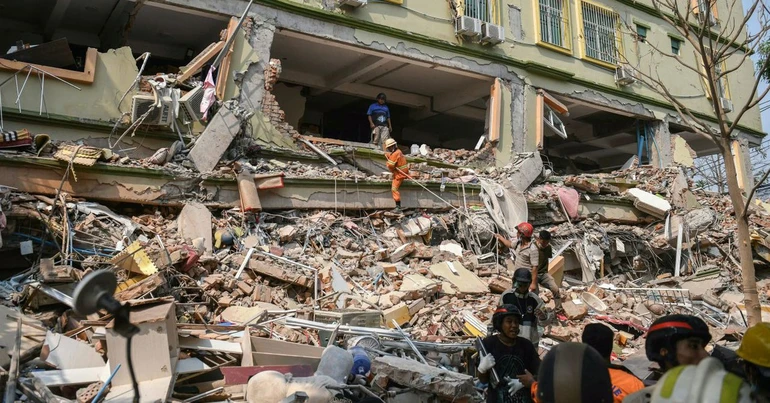 Các nhân viên cứu hộ cố gắng giải cứu những người bị mắc kẹt dưới đống đổ nát của tòa nhà bị phá hủy ở Mandalay, Myanmar ngày 29-3 - Ảnh: AFP