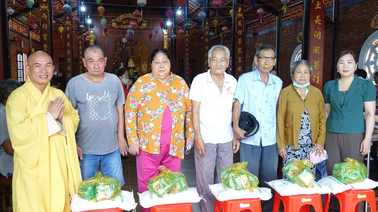 Thượng tọa Thích Minh Sơn, trụ trì chùa Linh Phước và bà Mai Thị Luyến, Chủ tịch Ủy ban MTTQVN xã Tân Phú Trung tặng quà đến bà con có hoàn cảnh khó khăn
