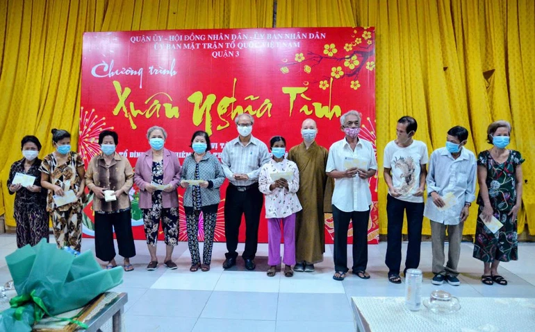 Đại đức Thích Nguyên Các cùng đại diện chính quyền trao tịnh tài đến bà con đón Tết - Ảnh: Công Minh