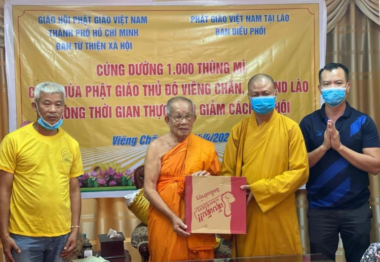 Thượng tọa Thích Minh Quang, đại diện Ban Từ thiện xã hội GHPGVN TP.HCM trao quà đến Hòa thượng Bounma Symaphom - Ảnh: C.Phật Tích