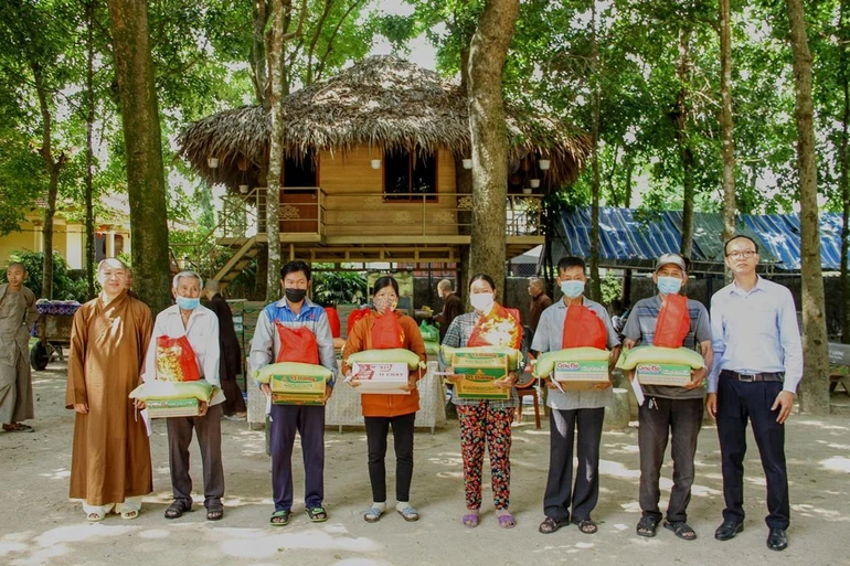 Thượng tọa Thích Thiện Thuận cùng đại diện Ủy ban MTTQVN thị trấn Phú Mỹ trạo quà đến bà con