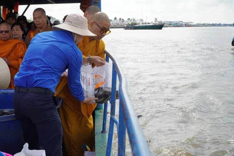 Thượng tọa Thích Quảng Lộc cùng chư tôn đức thả cá xuống sông Tiền