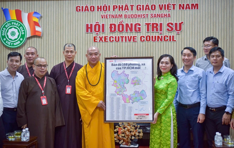 Bà Nguyễn Thanh Xuân tặng bản đồ 168 phường - xã TP.HCM đến Thượng tọa Thích Phước Nguyên - Ảnh: Quảng Đạo/BGN