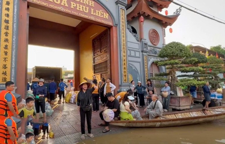 Bà con Phật tử chùa Phù Liễn dùng xuồng chở lương thực, thực phẩm đến tiếp tế bà con vùng ngập nặng tại tỉnh Thái Nguyên - Ảnh: PGTN