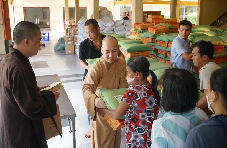 Tặng quà đến người dân khó khăn quận 3 đón Tết tại tổ đình Vĩnh Nghiêm chiều 14-1 - Ảnh: Thanh Tú