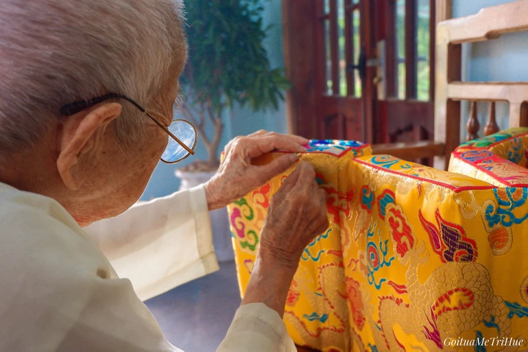Mệ Trí Huệ tỉ mẩn từng đường kim - Ảnh: Journeys in Hue
