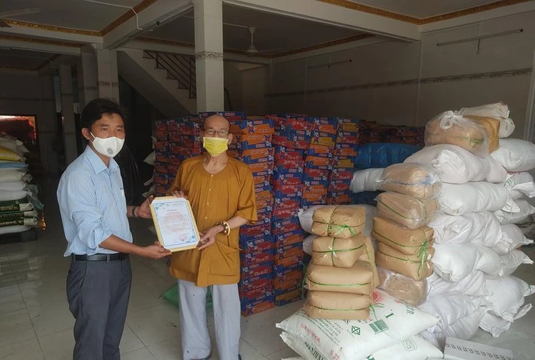 Thượng tọa Thích Thiện Nghĩa, Trưởng ban Trị sự Phật giáo quận 6 trao quà cho đại diện Ủy ban MTTQVN quận 6 