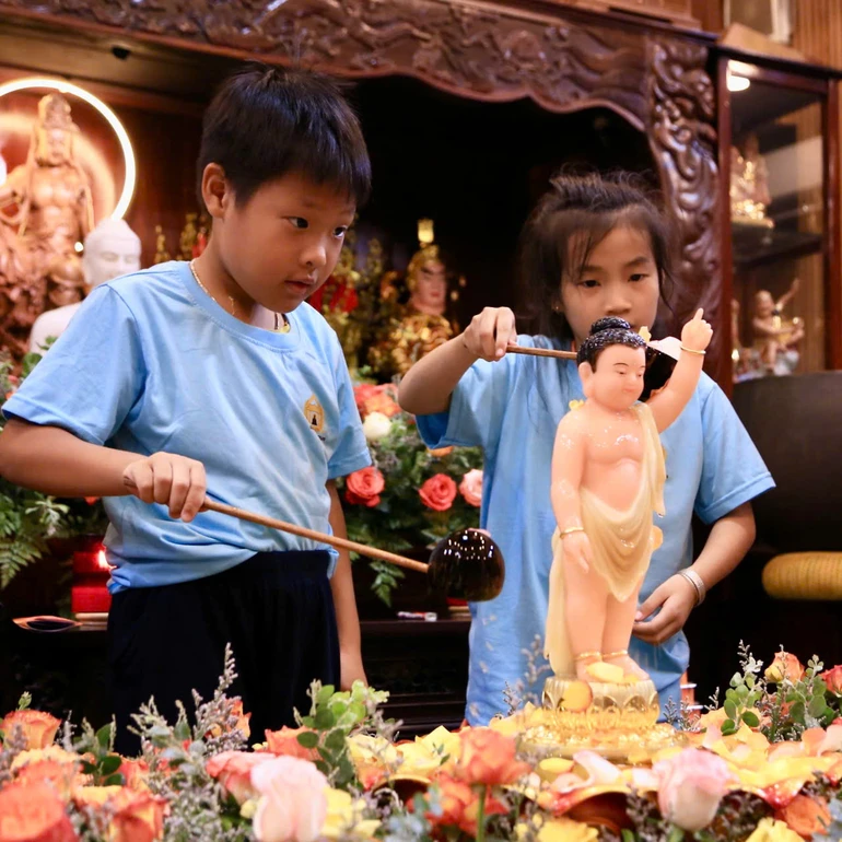 Khoảnh khắc các em thiếu nhi múc nước thơm Tắm Phật đem đến cho các em nhiều hỷ lạc 