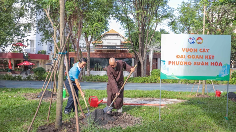 Ông Nguyễn Đình Phát, Phó Bí thư Thường trực Đảng ủy P.Xuân Hòa và Đại đức Thích Quảng Hậu, Phó Trị sự Báo Giác Ngộ trồng cây xanh tại Công viên Phan Đình Phùng - Ảnh: Nguyên Tài/BGN