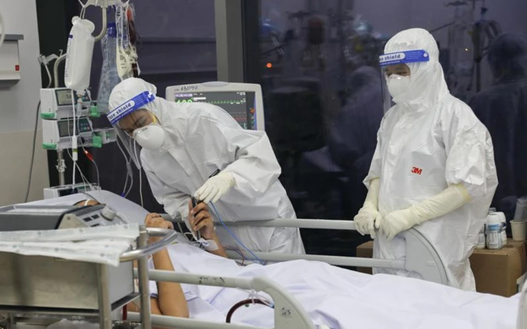 Nhân viên y tế Bệnh viện hồi sức Covid-19 cho bệnh nhân nói chuyện với người nhà - Ảnh: Quỳnh Trần