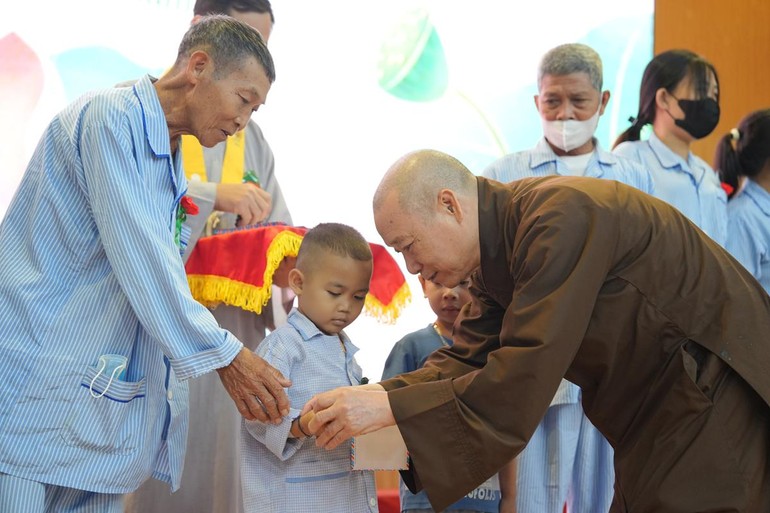 Hòa thượng Thích Bảo Nghiêm đeo chuỗi cho bệnh nhi