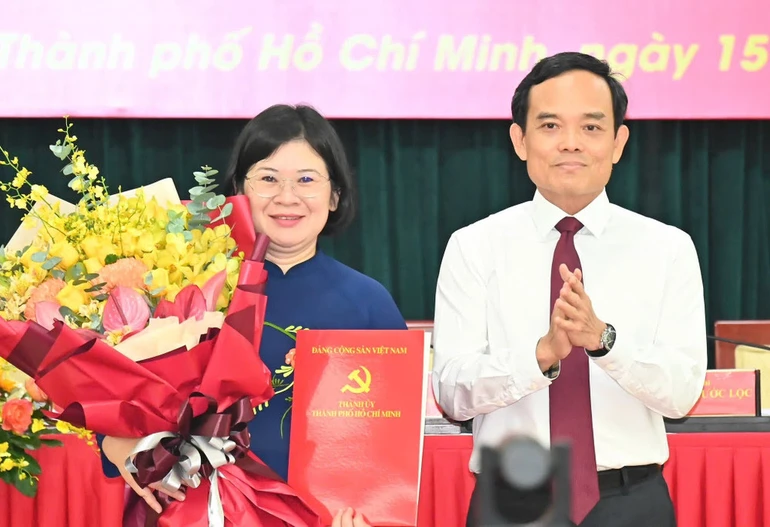 Bí thư Thành ủy TP.HCM Trần Lưu Quang trao quyết định và tặng hoa chúc mừng bà Văn Thị Bạch Tuyết