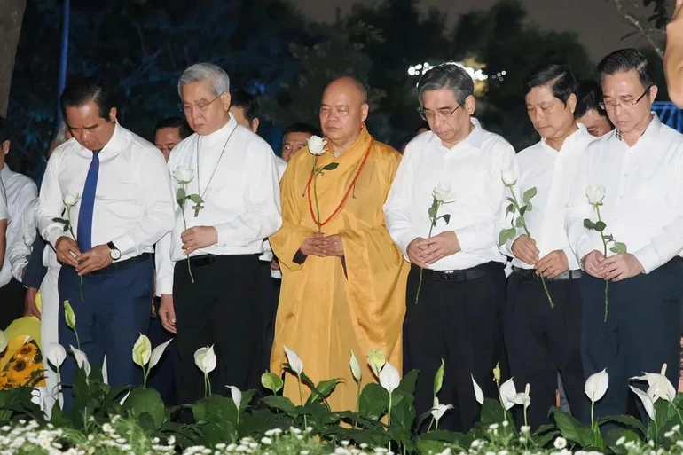 Các đại biểu dành một phút mặc niệm tưởng nhớ nạn nhân mất vì Covid-19. Ảnh: Hoàng Hùng/SGGP