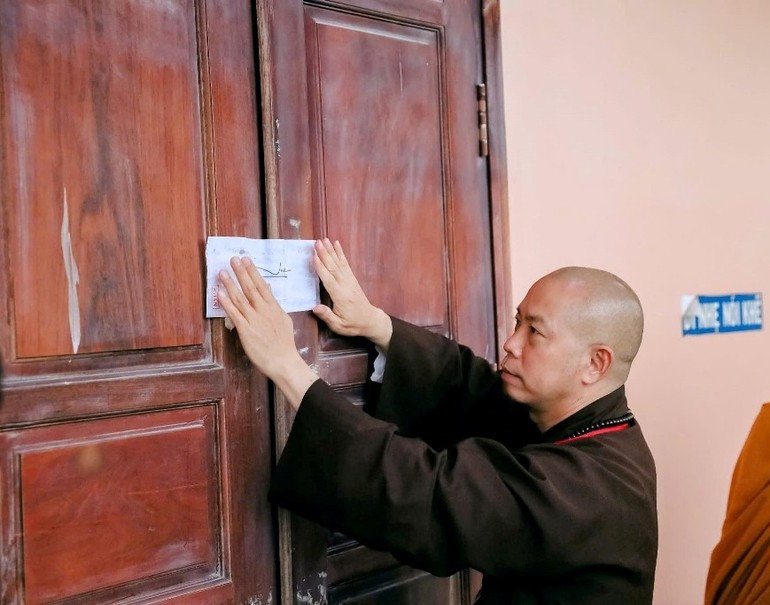 Thượng tọa Thích Quang Thạnh, Phó Viện trưởng, Tổng Thư ký Hội đồng Điều hành Học viện niêm phong phòng thi - Ảnh: Nhân Hòa