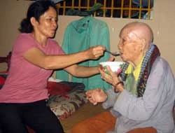 Chị Hà Thị Châu - một trong những người được chùa cưu mang nay hàng ngày phụ đút cơm cho các cụ già yếu