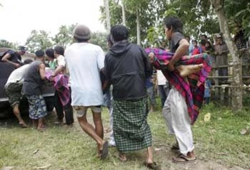 Cư dân địa phương đang khiêng hai nạn nhân lên xe