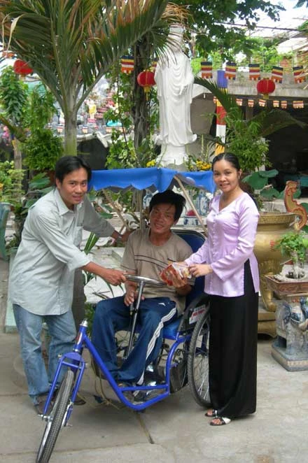 Tác giả (bìa phải) bên chiếc xe lắc tay tặng Vũ