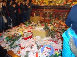 Tiền lẻ bị ném ẩu trên mặt phản ở Phủ Tây Hồ, Hà Nội và rơi trượt rất nhiều xuống đất. (Ảnh: Nguyễn Anh/ Vietnam+)