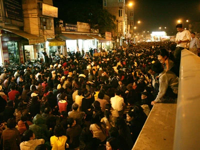 Không còn chỗ gửi xe, người phụ nữ ngày ngồi trên giải phân cách cầu vượt Ngã Tư Sở vừa làm lễ vừa trông xe.