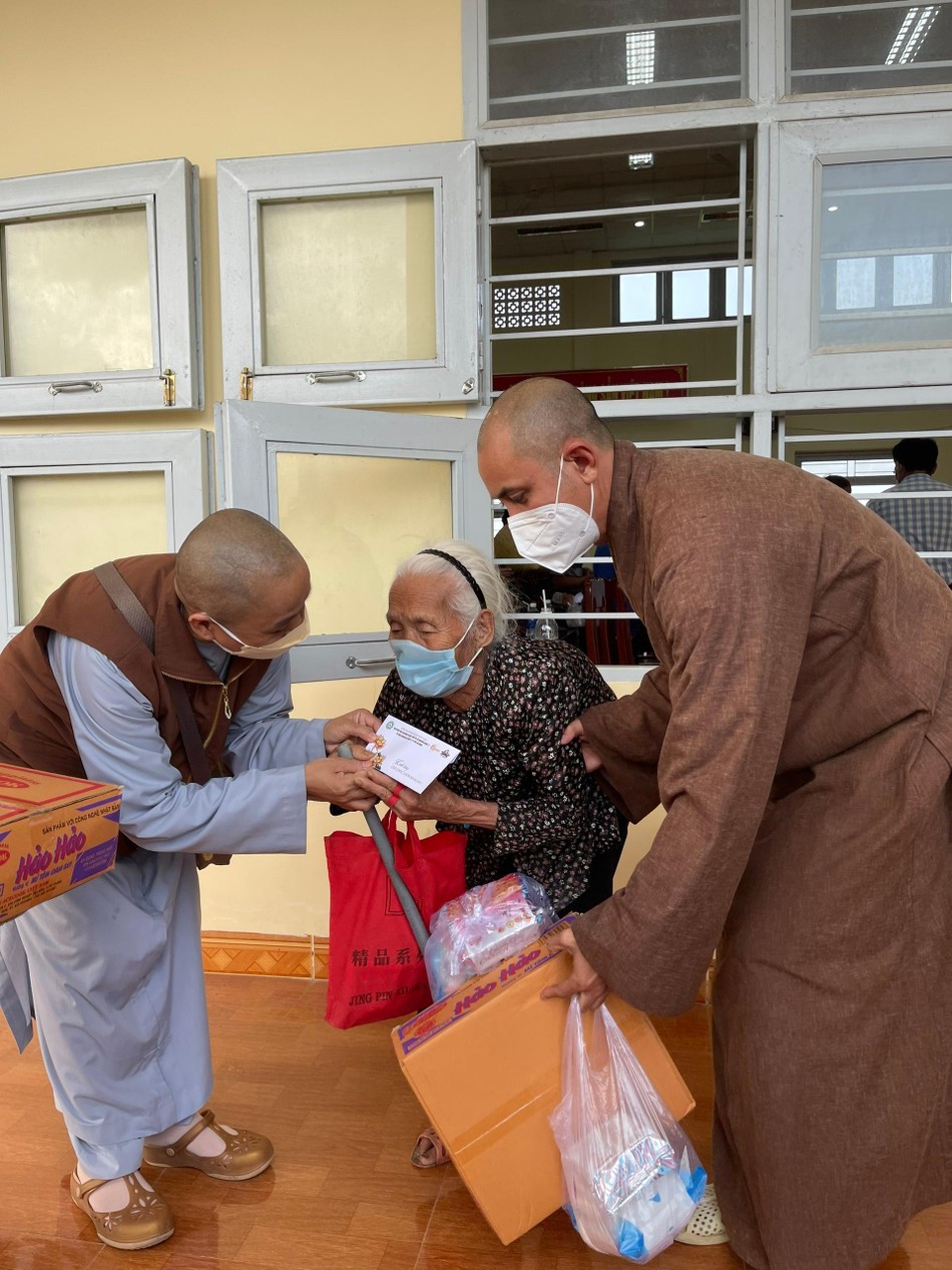 Các thành viên trong đoàn giúp đỡ một cụ già nhận quà Các thành viên trong đoàn giúp đỡ một cụ già nhận quà